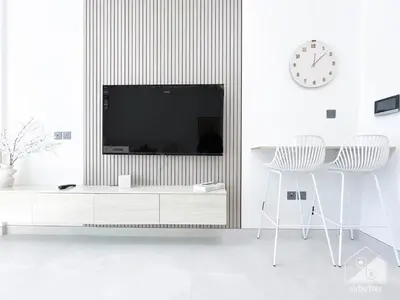a living room with a tv and a table and chairs at Luxurious Studio in Arjan With Balcony & Views in Dubai
