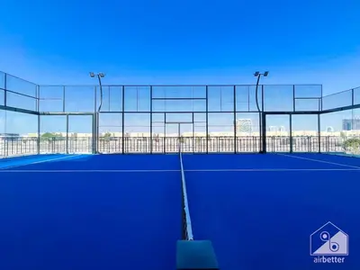 a tennis court with a net and lights on it at Luxurious Studio in Arjan With Balcony & Views in Dubai