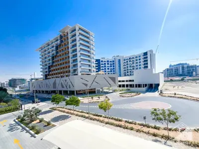an empty parking lot in front of a tall building at Luxurious Studio in Arjan With Balcony & Views in Dubai