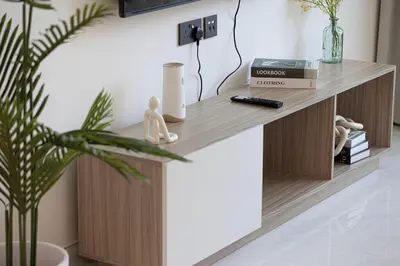 a wooden console table in a living room with a plant at NEW 2BR in Arjan with Private Pool in Dubai