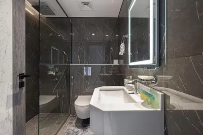 a bathroom with a sink and a toilet and a mirror at NEW 2BR in Arjan with Private Pool in Dubai