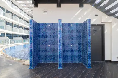 a blue tile wall next to a swimming pool at NEW 2BR in Arjan with Private Pool in Dubai