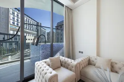 a living room with a couch and a large window at NEW 2BR in Arjan with Private Pool in Dubai
