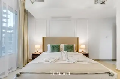 a bedroom with a bed with two towels on it at Luxury Studio Apartment in JVC near Circle Mall in Dubai