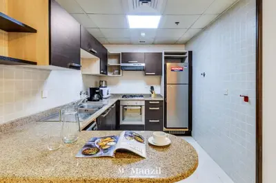 a kitchen with a table with a book on it at Luxury Studio Apartment in JVC near Circle Mall in Dubai