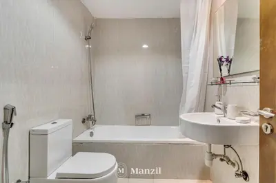 a bathroom with a toilet and a sink and a tub at Luxury Studio Apartment in JVC near Circle Mall in Dubai