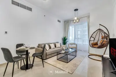 a living room with a couch and a table at Luxury Studio Apartment in JVC near Circle Mall in Dubai