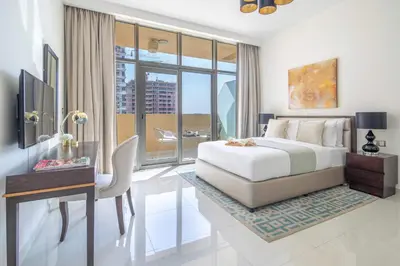 a bedroom with a bed and a desk with a desk at Frank Porter - Damac Ghalia in Dubai