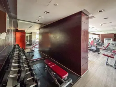 a gym with a red bench and chairs in it at Frank Porter - Damac Ghalia in Dubai