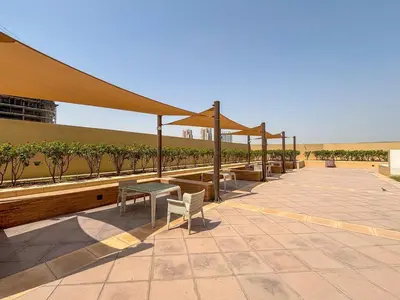 a patio with a table and benches and a canopy at Frank Porter - Damac Ghalia in Dubai