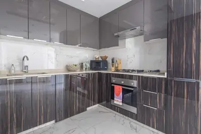 a kitchen with wooden cabinets and a stove at Frank Porter - Golden Dream Tower in Dubai