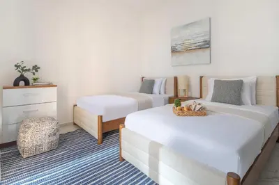 a bedroom with two beds and a dresser in it at Frank Porter - Golden Dream Tower in Dubai