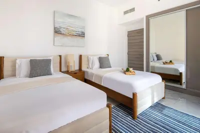 a bedroom with two beds and a mirror at Frank Porter - Golden Dream Tower in Dubai
