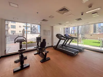 a gym with cardio equipment and a large window at Frank Porter - Golden Dream Tower in Dubai