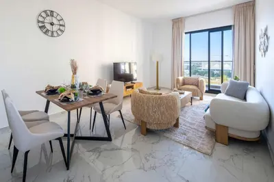 a living room with a table and chairs and a living room at Frank Porter - Golden Dream Tower in Dubai