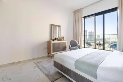 a white bedroom with a bed and a window at Frank Porter - Golden Dream Tower in Dubai