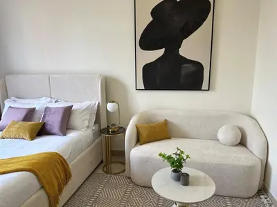 a living room with a couch and a hat on the wall at Modern Studio Near Burj Khalifa in Dubai
