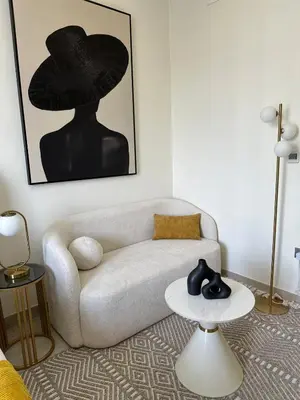 a living room with a white couch and a black hat at Modern Studio Near Burj Khalifa in Dubai