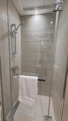 a bathroom with a shower with a white towel at Modern Studio Near Burj Khalifa in Dubai
