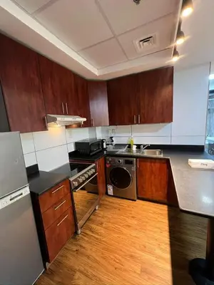 a kitchen with wooden cabinets and a stove top oven at Dubai Marina Escan Tower Family Apartment in Dubai