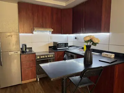 a kitchen with a table with a vase of flowers on it at Dubai Marina Escan Tower Family Apartment in Dubai