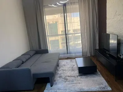 a living room with a couch and a large window at Dubai Marina Escan Tower Family Apartment in Dubai