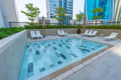 a large swimming pool with chairs and avisorvisor at Keyrock Living - Lakeview Luxury with Pool Access in Dubai