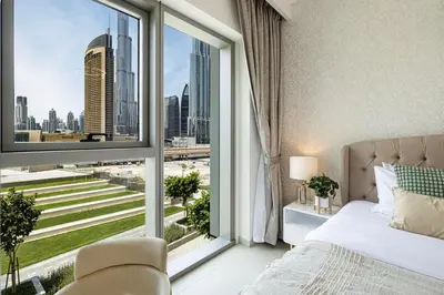 a bedroom with a large window with a view of the city at Beautiful 2BR - Burj Views And Dubai Mall Connection in Dubai