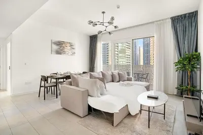 a living room with a white couch and a table at Modern 1BR Apartment Steps from Beach and Dubai Nightlife in Dubai