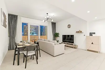 a living room with a couch and a table at Modern 1BR Apartment Steps from Beach and Dubai Nightlife in Dubai