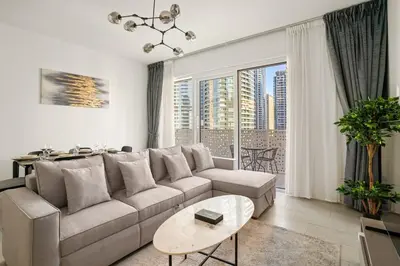 a living room with a couch and a table at Modern 1BR Apartment Steps from Beach and Dubai Nightlife in Dubai