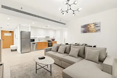 a living room with a couch and a table at Modern 1BR Apartment Steps from Beach and Dubai Nightlife in Dubai