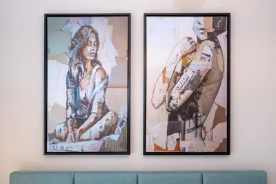 three framed pictures on a wall above a couch at Keyrock - Zada Tower, Business Bay Lake-View Apartment in Dubai