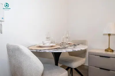 a dining room table with chairs and glasses on it at Blue Breeze - Stylish Studio Retreat in MBR City in Dubai