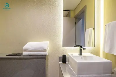 a bathroom with a white sink and a mirror at Blue Breeze - Stylish Studio Retreat in MBR City in Dubai