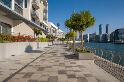 a sidewalk next to a river with buildings at CanalFront - Central Location up to 7 Guests in Dubai