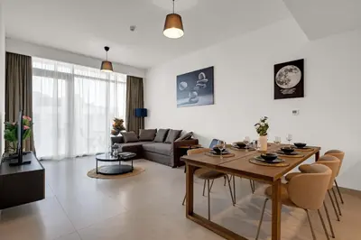 a living room with a wooden table and chairs at CanalFront - Central Location up to 7 Guests in Dubai