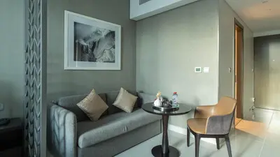 a living room with a couch and a table at Keyrock Damac Maison Privée - Studio in Business Bay with Pool, Gym & Free Parking in Dubai