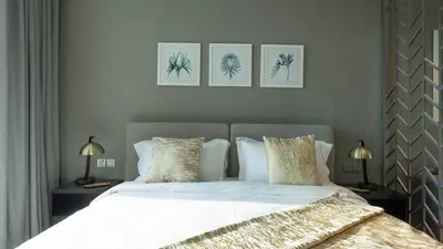 a bedroom with a bed with four pictures on the wall at Keyrock Damac Maison Privée - Studio in Business Bay with Pool, Gym & Free Parking in Dubai