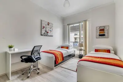 a bedroom with two beds and a desk and a chair at GuestReady - Contemporary haven in Dubai Marina in Dubai