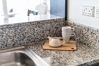 a kitchen counter with a coffee pot on a cutting board at GuestReady - Contemporary haven in Dubai Marina in Dubai