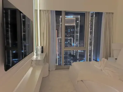 a living room with a white couch and a large window at Stunning 1BR Burj View from Infinity Pool in Dubai