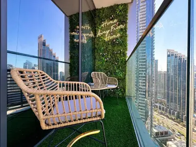 a balcony with chairs and tables on top of a building at Stunning 1BR Burj View from Infinity Pool in Dubai