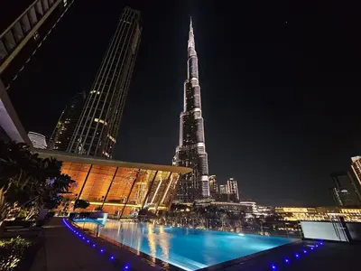 a view of a tall building at night at Stunning 1BR Burj View from Infinity Pool in Dubai