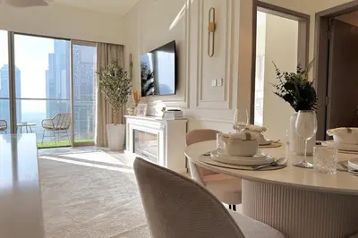 a dining room with a table with chairs and a fireplace at Stunning 1BR Burj View from Infinity Pool in Dubai