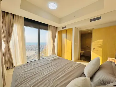 a bedroom with a large bed and a large window at 2 Bedroom Fully Furnished- Aykon City Tower C in Dubai