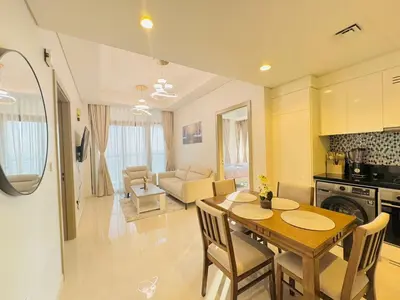 a kitchen and living room with a wooden table and chairs at 2 Bedroom Fully Furnished- Aykon City Tower C in Dubai