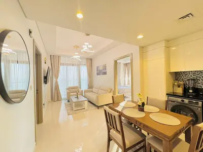 a kitchen and living room with a wooden table and chairs at 2 Bedroom Fully Furnished- Aykon City Tower C in Dubai