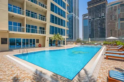 a swimming pool in the middle of a building with tall buildings at Luxury JLT Studio Lake View Metro 5minMarina in Dubai