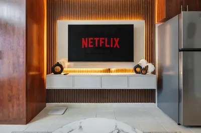 a television on a wall with a netflix sign at Luxury JLT Studio Lake View Metro 5minMarina in Dubai
